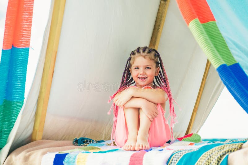 Sisters spending time in a tent on camping. Children using tablet playing games  online during summer vacation - a Royalty Free Stock Photo from Photocase