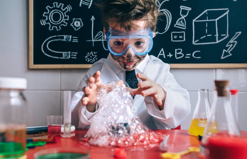 Portrait of happy little boy scientist with glasses and dirty face opening his arms behind of glass with soap foam. Portrait of happy little boy scientist with glasses and dirty face opening his arms behind of glass with soap foam