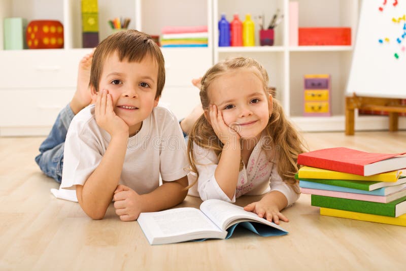 Happy kids with books laying on the floor royalty free stock image Happy kids with books laying on the floor royalty free stock image