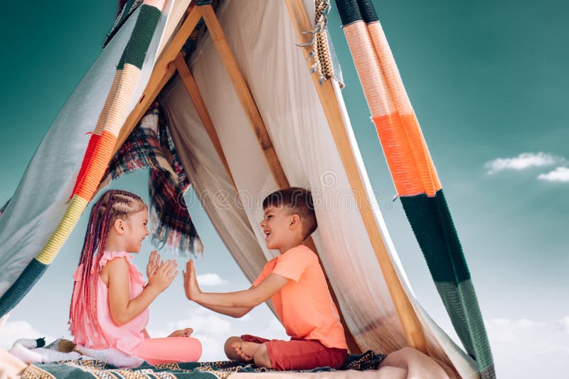 Sisters spending time in a tent on camping. Children using tablet playing games  online during summer vacation - a Royalty Free Stock Photo from Photocase