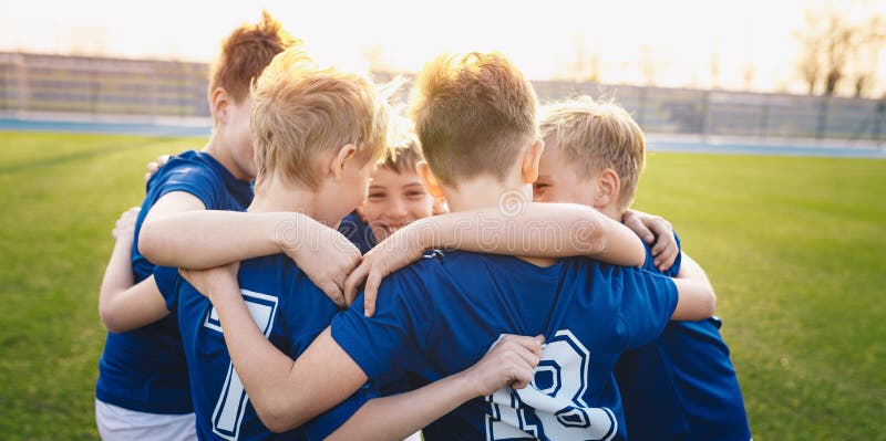 Happy kids in elementary school sports team celebrating soccer success in tournament final game