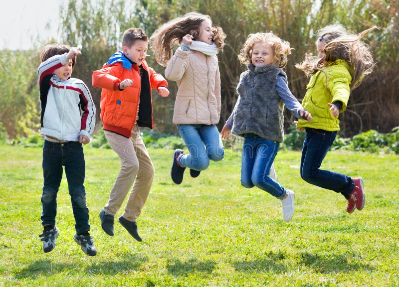 Group of five happy children jumping outdoors., Group of fi…