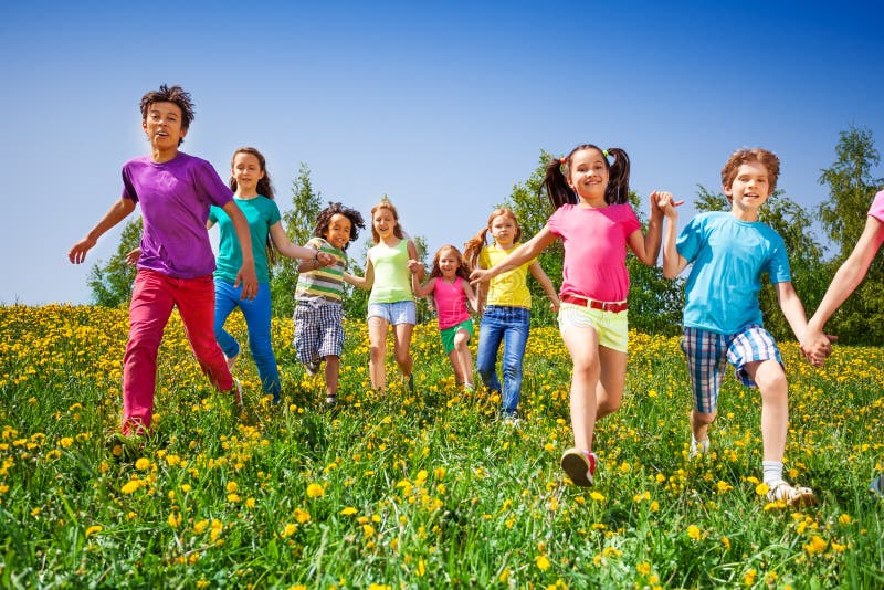 Happy kids run and hold hands in green meadow stock photography Happy kids run and hold hands in green meadow stock photography