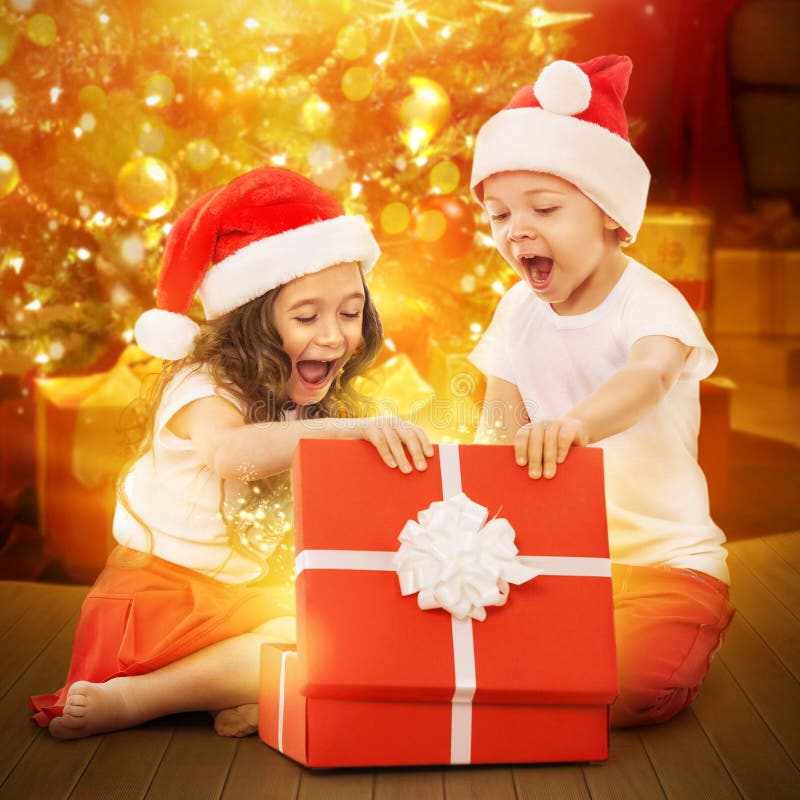 Happy kids in Santa hat opening a gift box