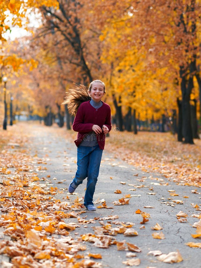 Happy-Kind Mädchen, das im Herbststädpark läuft, spielt, posiert, lächelt und Spaß hat. Hellgelbe Bäume und Blätter lizenzfreie stockbilder Happy-Kind Mädchen, das im Herbststädpark läuft, spielt, posiert, lächelt und Spaß hat. Hellgelbe Bäume und Blätter lizenzfreie stockbilder