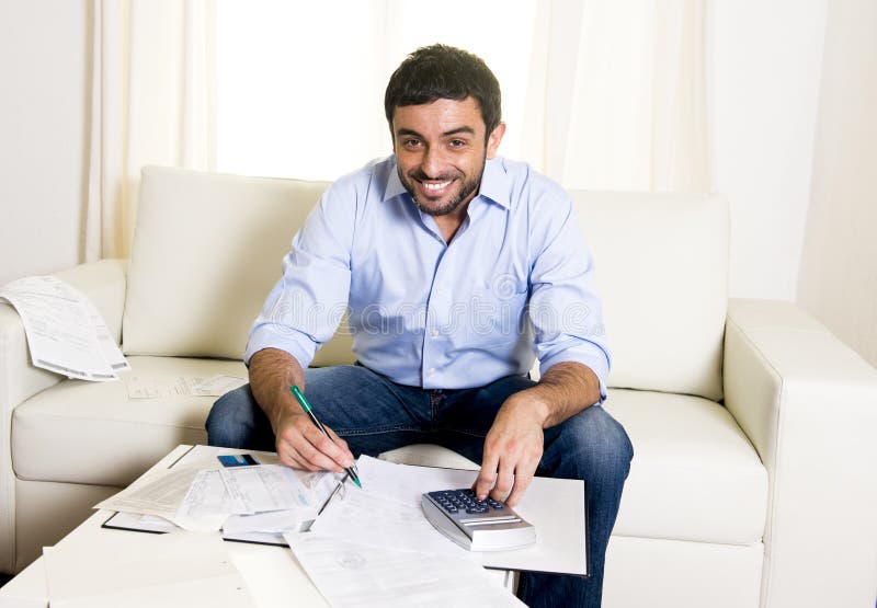 Happy latin man paying bills and credit card on sofa royalty free stock photo Happy latin man paying bills and credit card on sofa royalty free stock photo