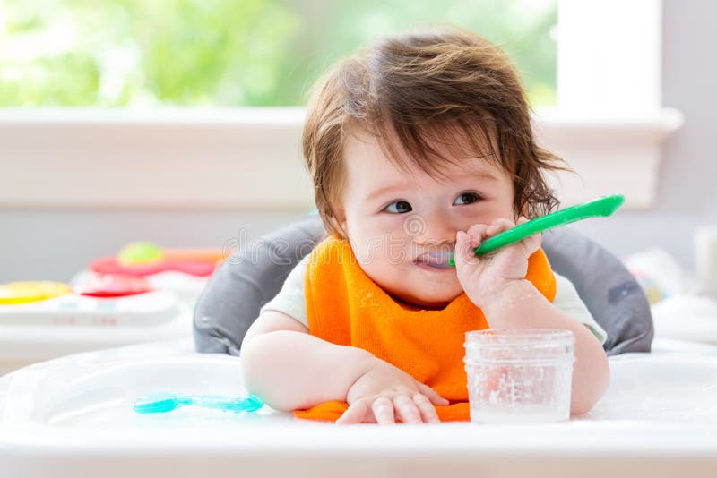 Happy little baby boy eating food stock image Happy little baby boy eating food stock image