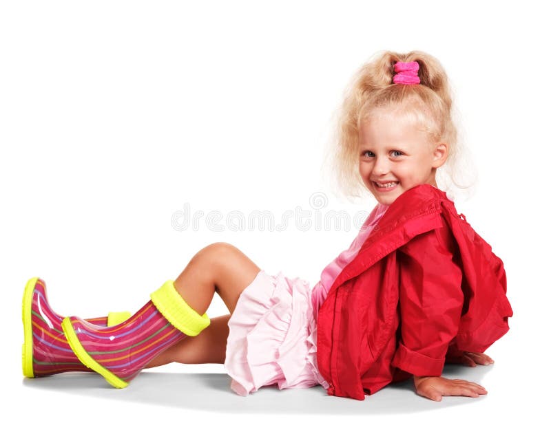 Happy little blonde girl in jacket , rubber boots, skirt isolated.