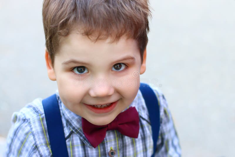 Happy Little Boy with Bow Tie Smiles and Looks at Camera Stock Image
