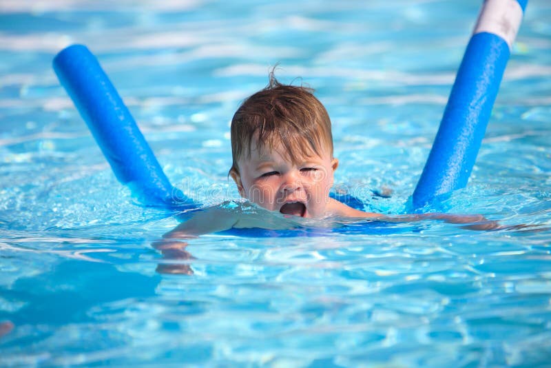 Šťastný malý chlapec štúdium na plávať bazén rezance.