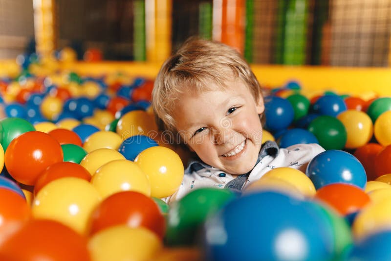 Happy Little Boy nuota in una piscina di baseball nel parco divertimenti immagini stock libere da diritti