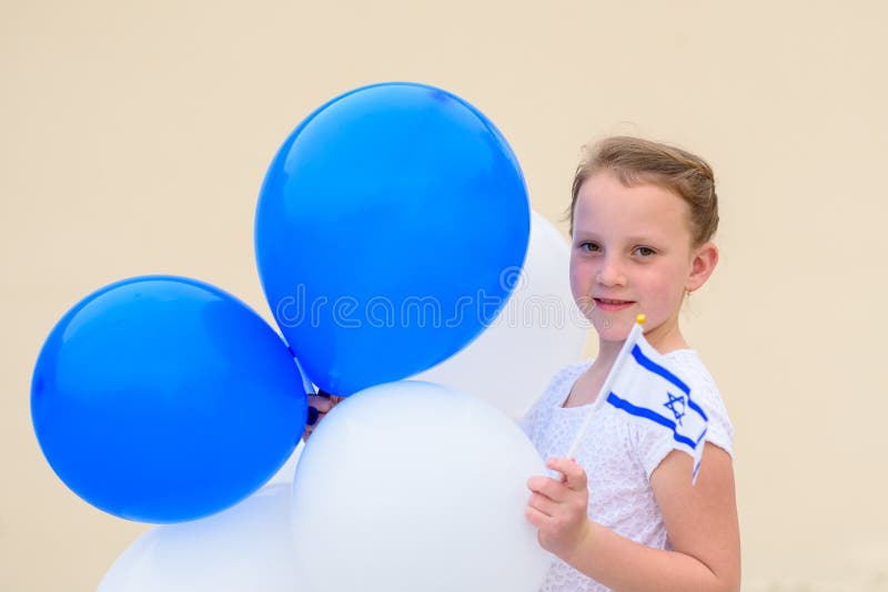 Happy little girl with blue and white balloons ans Israel flag.