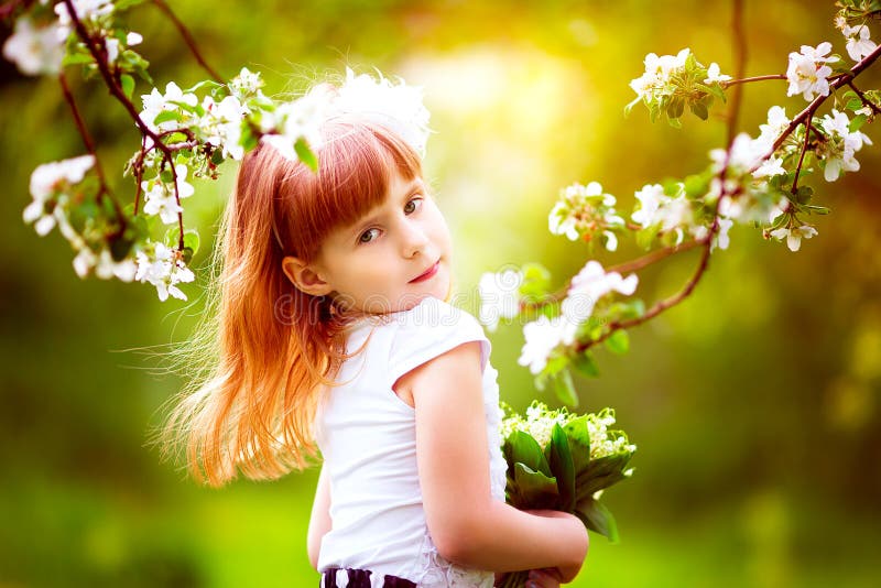 Happy little girl with a bouquet of lilies of the valley having