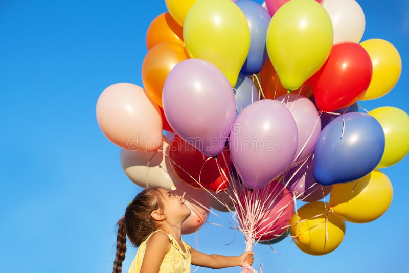 Happy little girl child kid with balloons on sky background