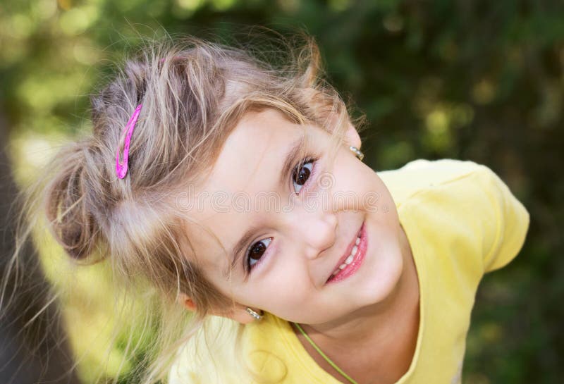 Happy little girl.Child outdoor closeup smiling face.