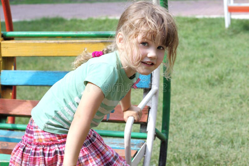 Happy little girl on colorful swing