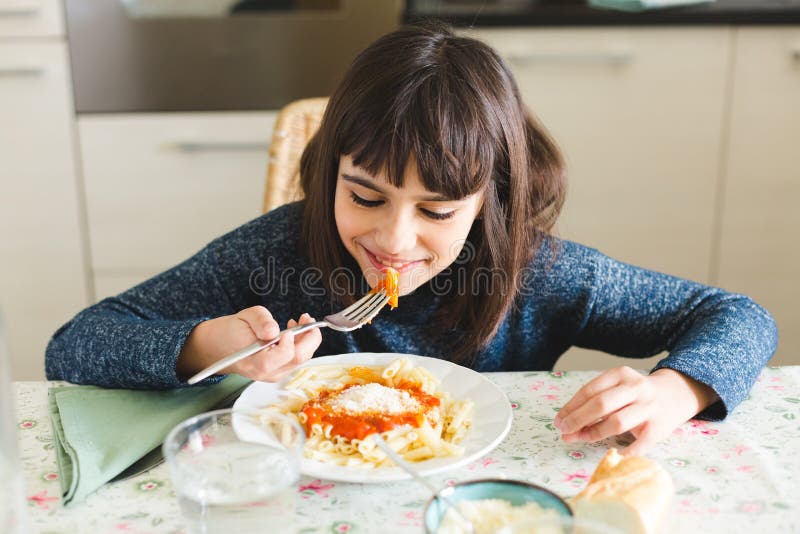 Девочка ест макароны. Ребенок есть макароны стоковые фото. She the dishes already