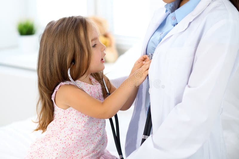 Happy little girl at health exam at doctor office. Medicine and health care concept