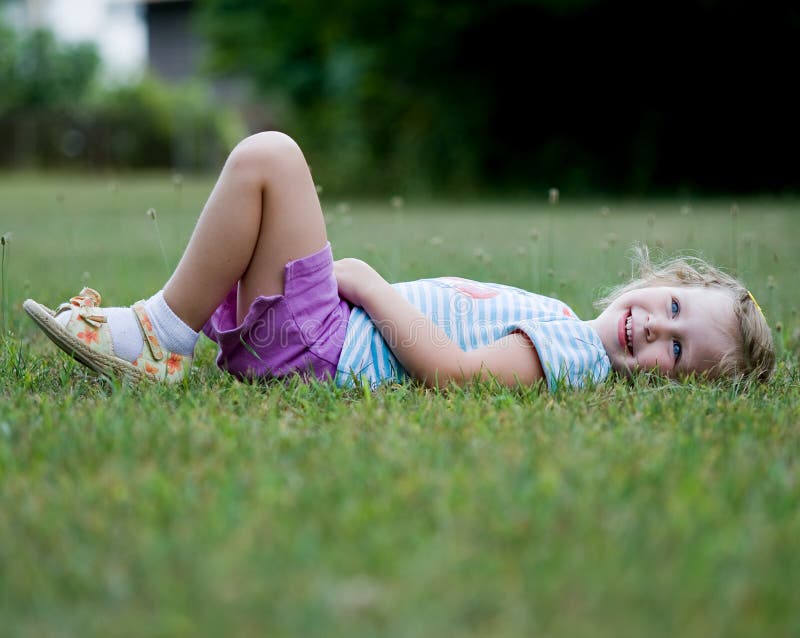 Happy Little Girl Laying in Grass