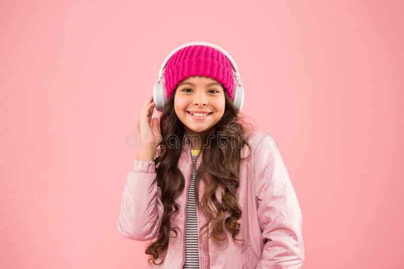 Happy little girl live pink life. pink is her favorite color. small kid listen music headset. child long curly hair