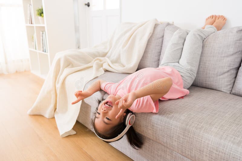 Happy little girl lying on the couch