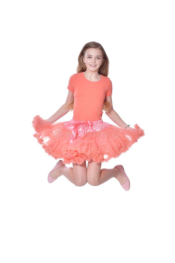 Happy little girl in pink dress jumping