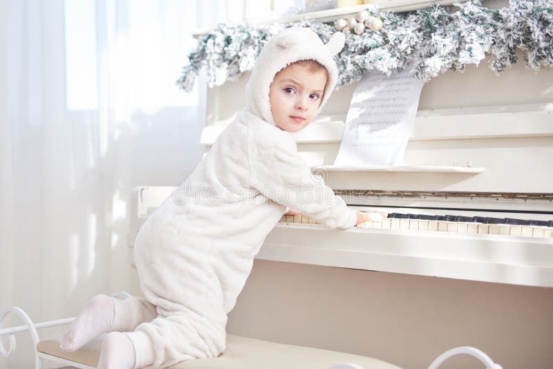 Happy little girl play the piano on Christmas day stock photo Happy little girl play the piano on Christmas day stock photo
