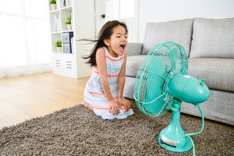 Happy little girl playing electric fan at home royalty free stock images Happy little girl playing electric fan at home royalty free stock images