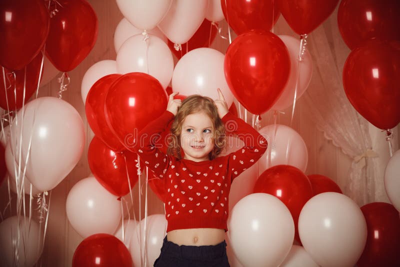 Happy little girl with red and white balloons