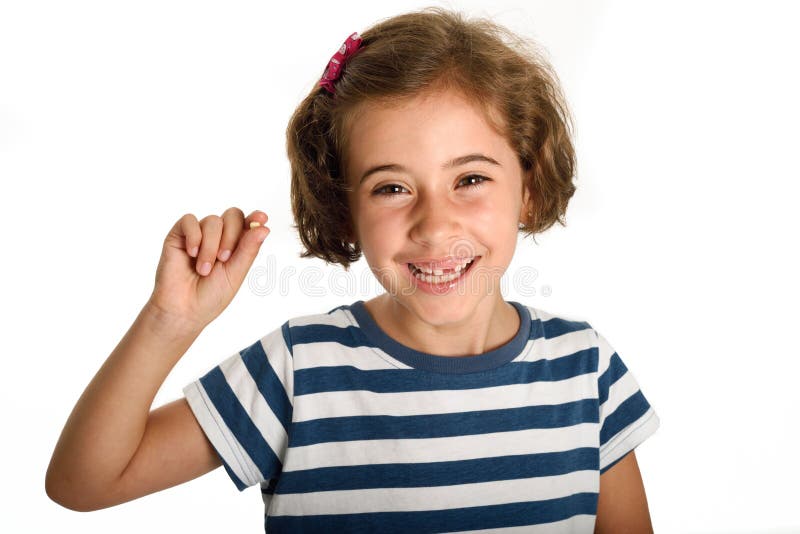 Happy little girl showing her first fallen tooth.