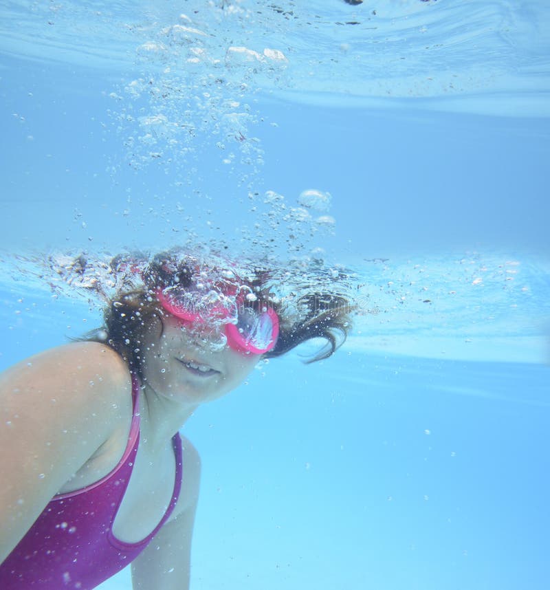 A happy little girl swimming in a pool