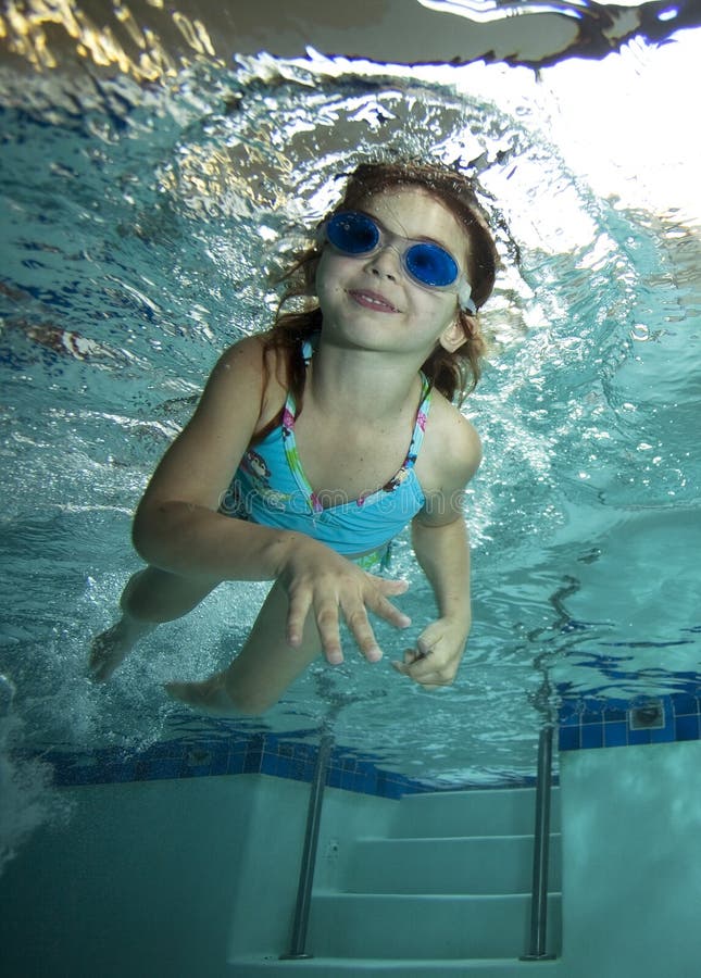 Happy little girl underwater in pool