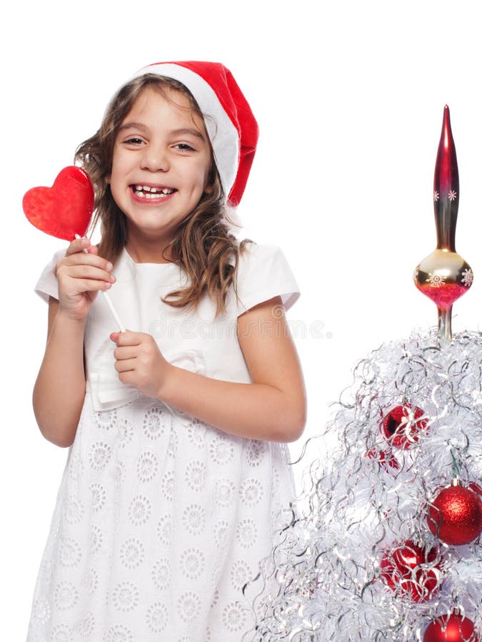 Happy Little Girl Wearing Santa Hat with lollipop