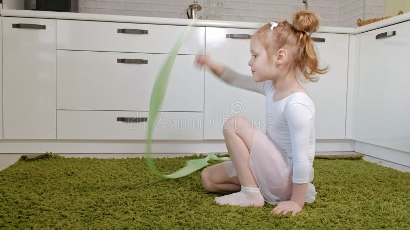 A Happy Little Girl in a White Gymnastic Swimsuit Trains, Dances with a Ribbon for Rhythmic Gymnastics, Jumps and Stock Video - Video of girl, aerobics: 139417687