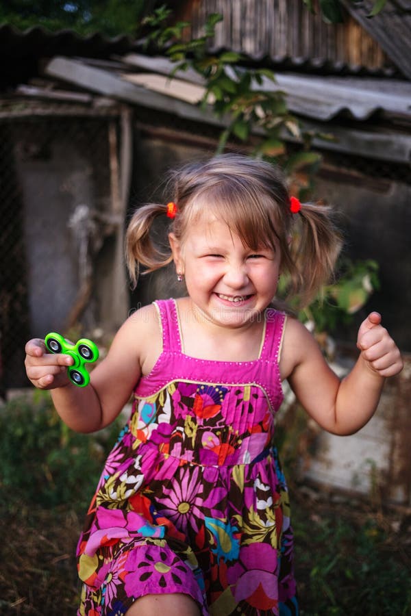 Happy little rural girl with a spinner in her hand