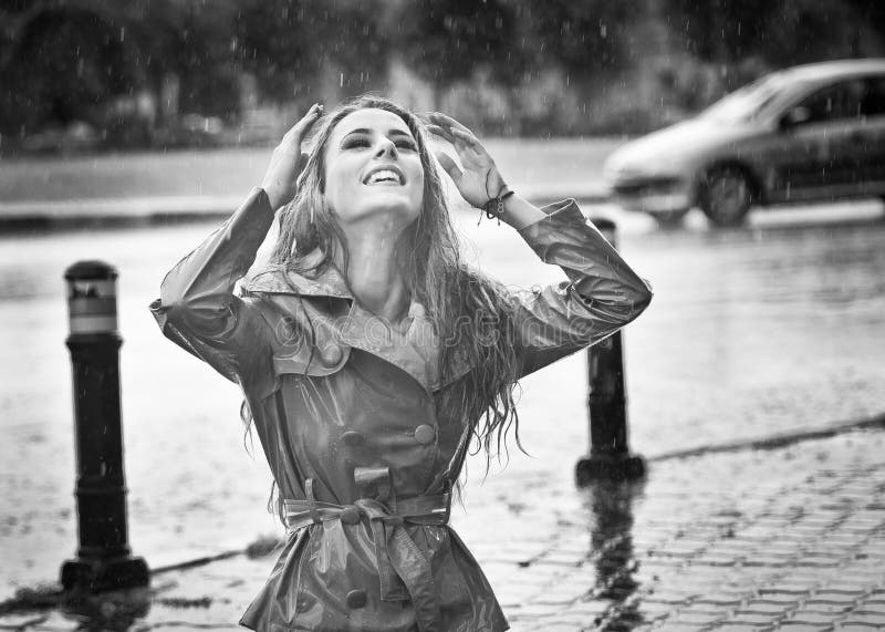 Happy long hair girl enjoying the rain drops in the park