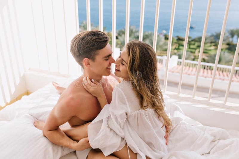 Happy long-haired girl gently embracing her smiling boyfriend and going to kiss him. Beautiful young couple cute hugging stock photography Happy long-haired girl gently embracing her smiling boyfriend and going to kiss him. Beautiful young couple cute hugging stock photography