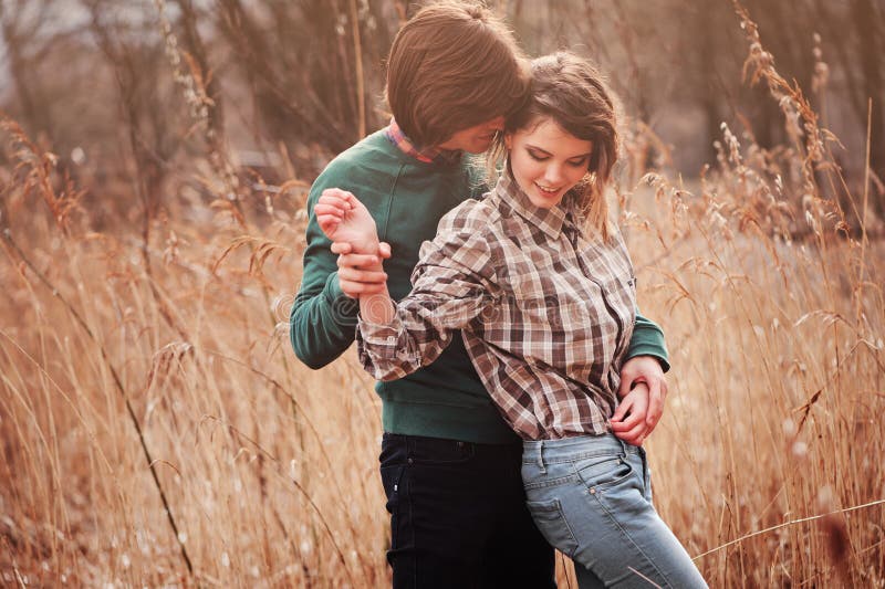 Happy loving couple on the walk in early spring field