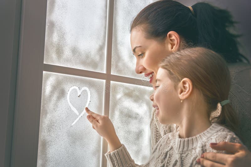 Family drawing a heart on frozen glass stock image Family drawing a heart on frozen glass stock image