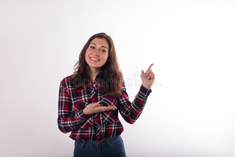 Happy lächelnde hübsche Frau gekleidet in stilvollen Gelegenheitskleidung mit Zeigefinger auf Kopierplatz Hintergrund für Werbebo lizenzfreies stockbild
