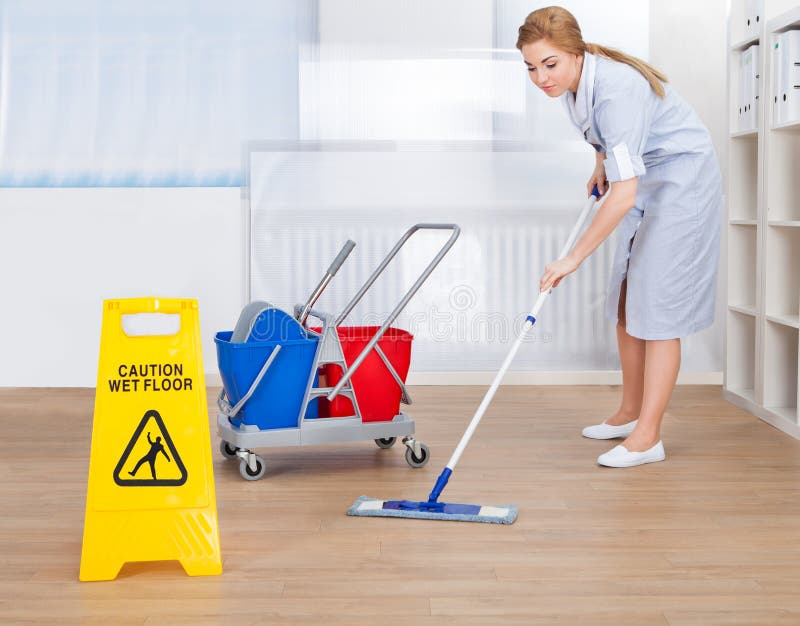 Happy maid cleaning floor with mop royalty free stock photo