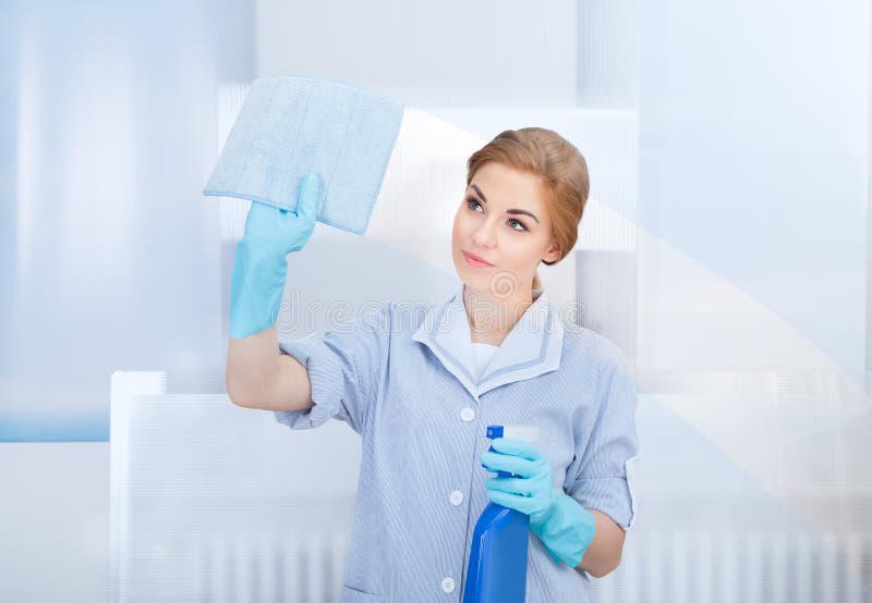 Happy maid cleaning glass royalty free stock photos