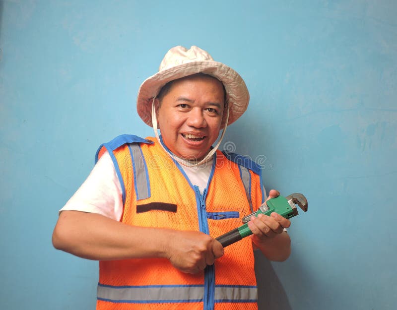 Happy Maintenance Worker Holding Pipe Wrench in Studio Shot photos libres de droits