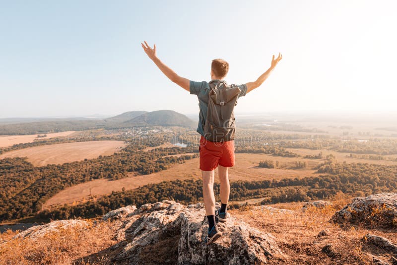 Happy male traveler with a backpack climbed to the top of Mount Shikhan in Bashkiria and admires the views royalty free stock photos