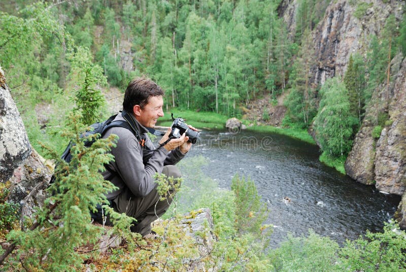 Šťastný fotograf je na z kopec proti les rieka plný z pereje.