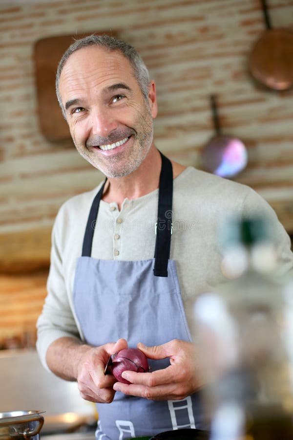 Happy man cooking in kitchen stock photo