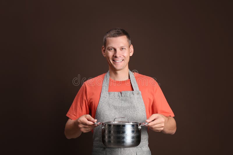 Happy man with cooking pot on brown background stock photos