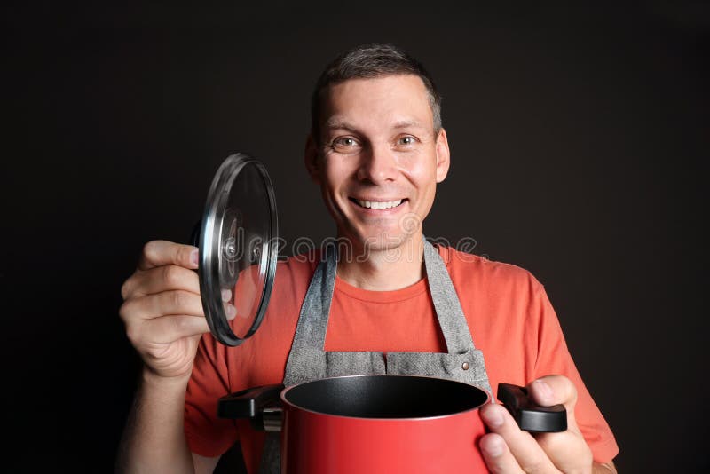 Happy man with cooking pot on brown background stock photography