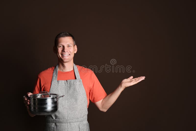 Happy man with cooking pot on brown background. Space for text royalty free stock photography