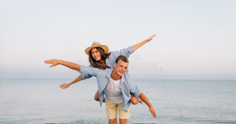 Free Photo  Man giving piggyback ride to woman on the beach